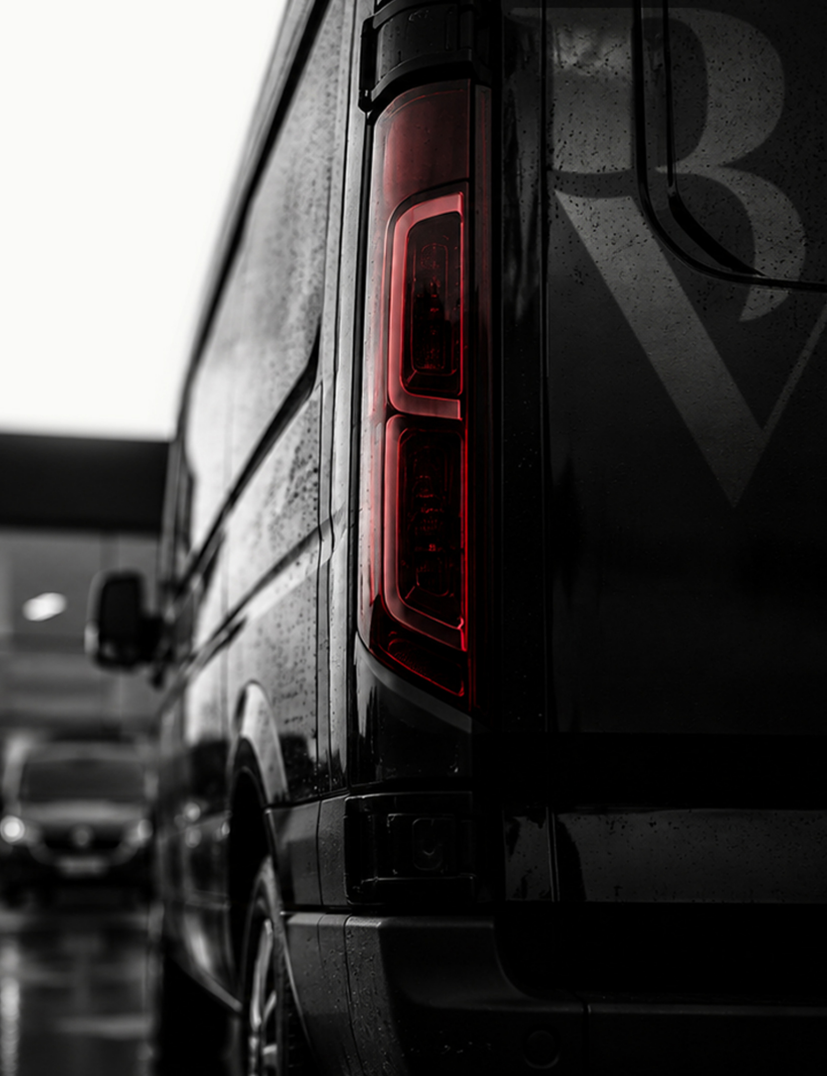 Close detail of a black van and illuminated red rear light